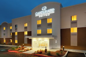 A hotel with a prominent sign, multiple windows, and a well-lit entrance.