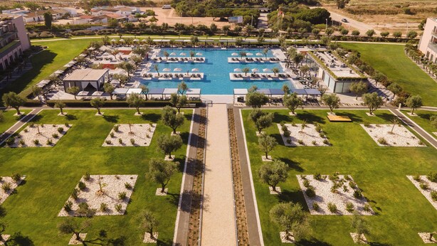 An aerial view of a resort with a central swimming pool, multiple lounge areas, and a beachfront. - Vila Gale Lagos Resort Hotel (Lagos)