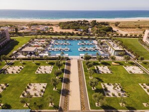 An aerial view of a resort with a central swimming pool, multiple lounge areas, and a beachfront. - Vila Gale Lagos Resort Hotel (Lagos)