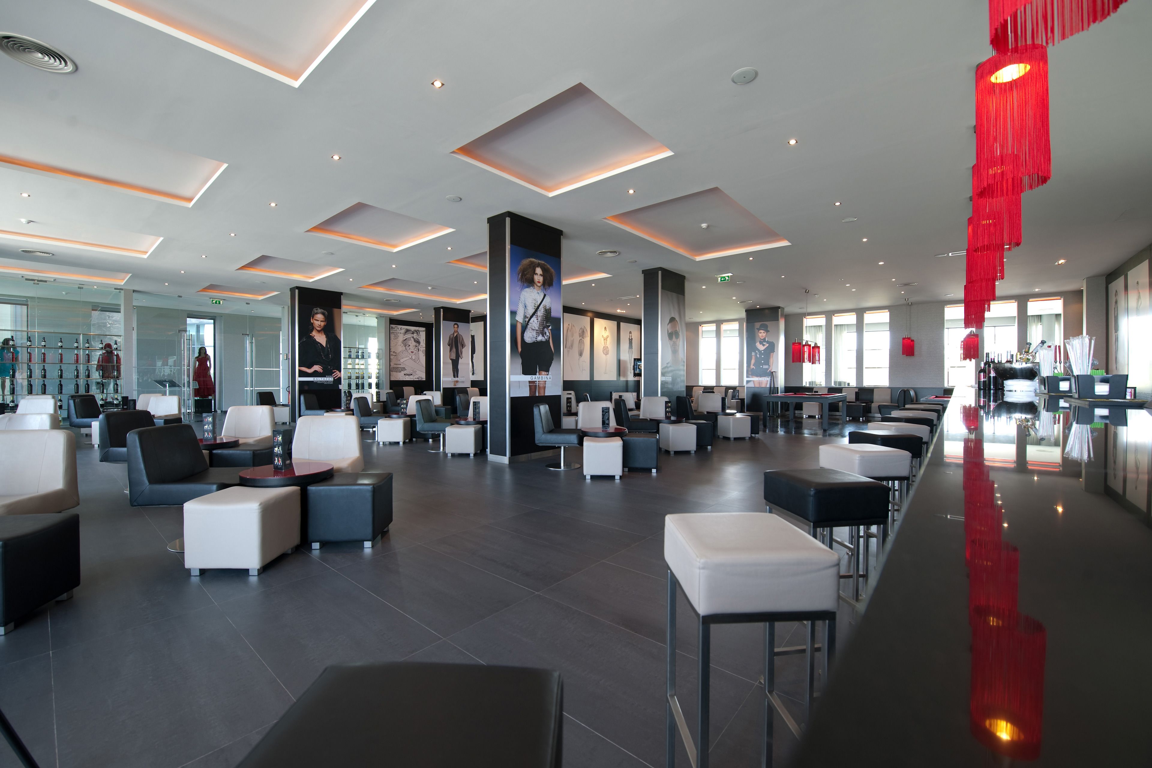 A spacious lobby with modern seating, large windows, and a prominent red decorative element.