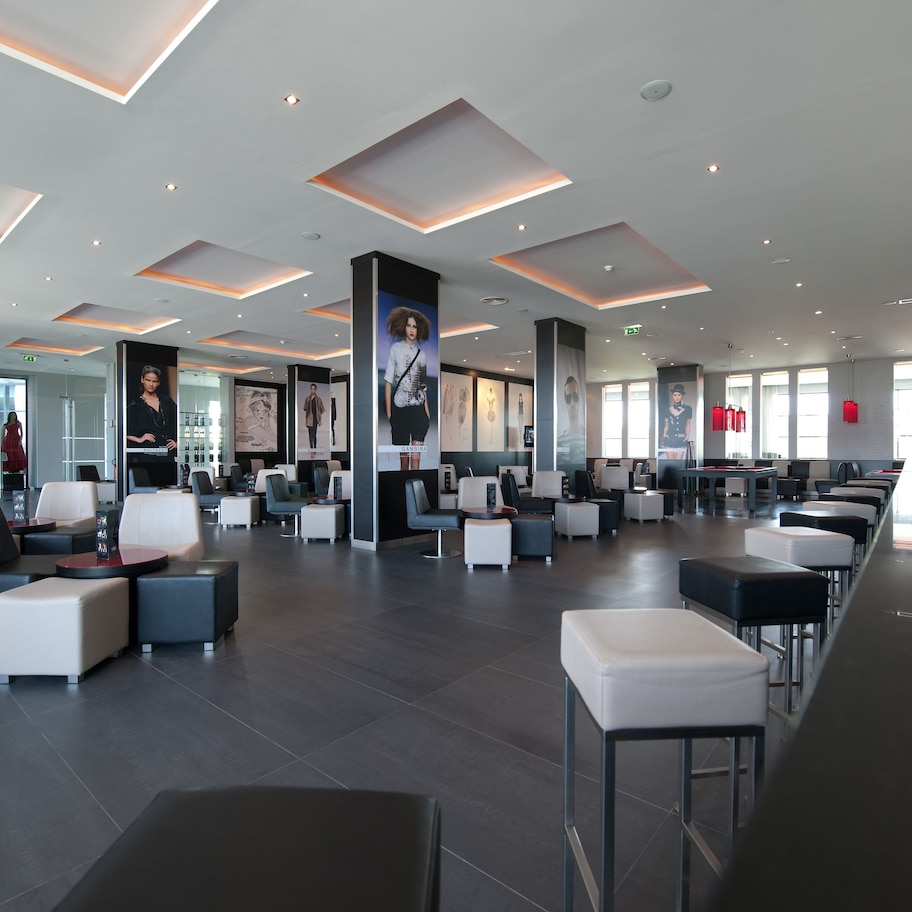 A spacious lobby with modern seating, large windows, and a prominent red decorative element.