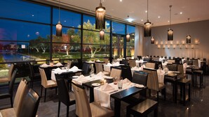 A restaurant with tables set for dining, large windows, and hanging pendant lights. - Vila Gale Lagos Resort Hotel (Lagos)