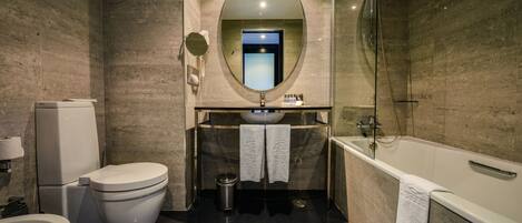 Un bagno moderno con WC, bidet, lavabo e vasca da bagno.