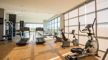 A gym with treadmills, elliptical machines, and weight benches.
