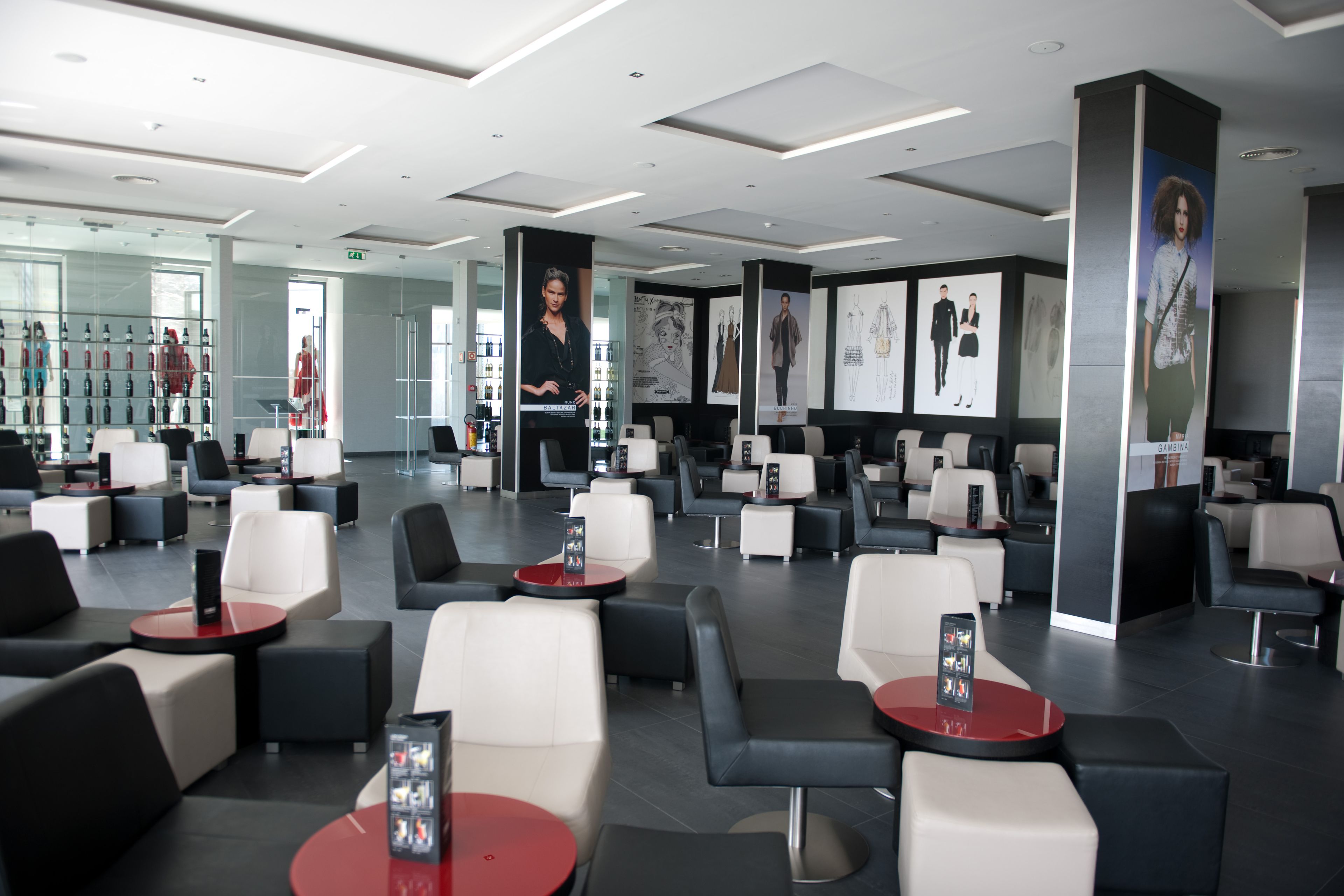 A modern lounge area with multiple seating options, including sofas and chairs, arranged around tables.