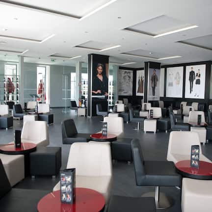 A modern lounge area with multiple seating options, including sofas and chairs, arranged around tables.