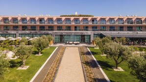 A multi-story hotel with a central courtyard, outdoor seating, and a clear sky. - Vila Gale Lagos Resort Hotel (Lagos)
