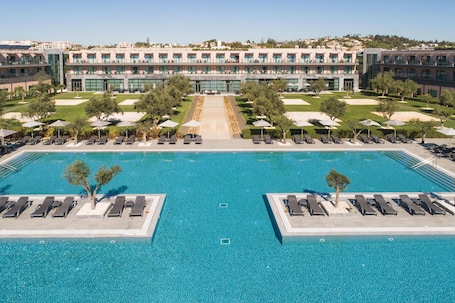 Una piscina techada, una piscina al aire libre, sombrillas