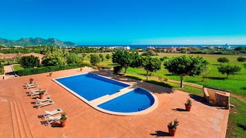 Una piscina al aire libre de temporada, sombrillas, tumbonas