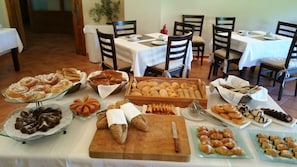 Una mesa de buffet con diversos productos horneados y pastelería.