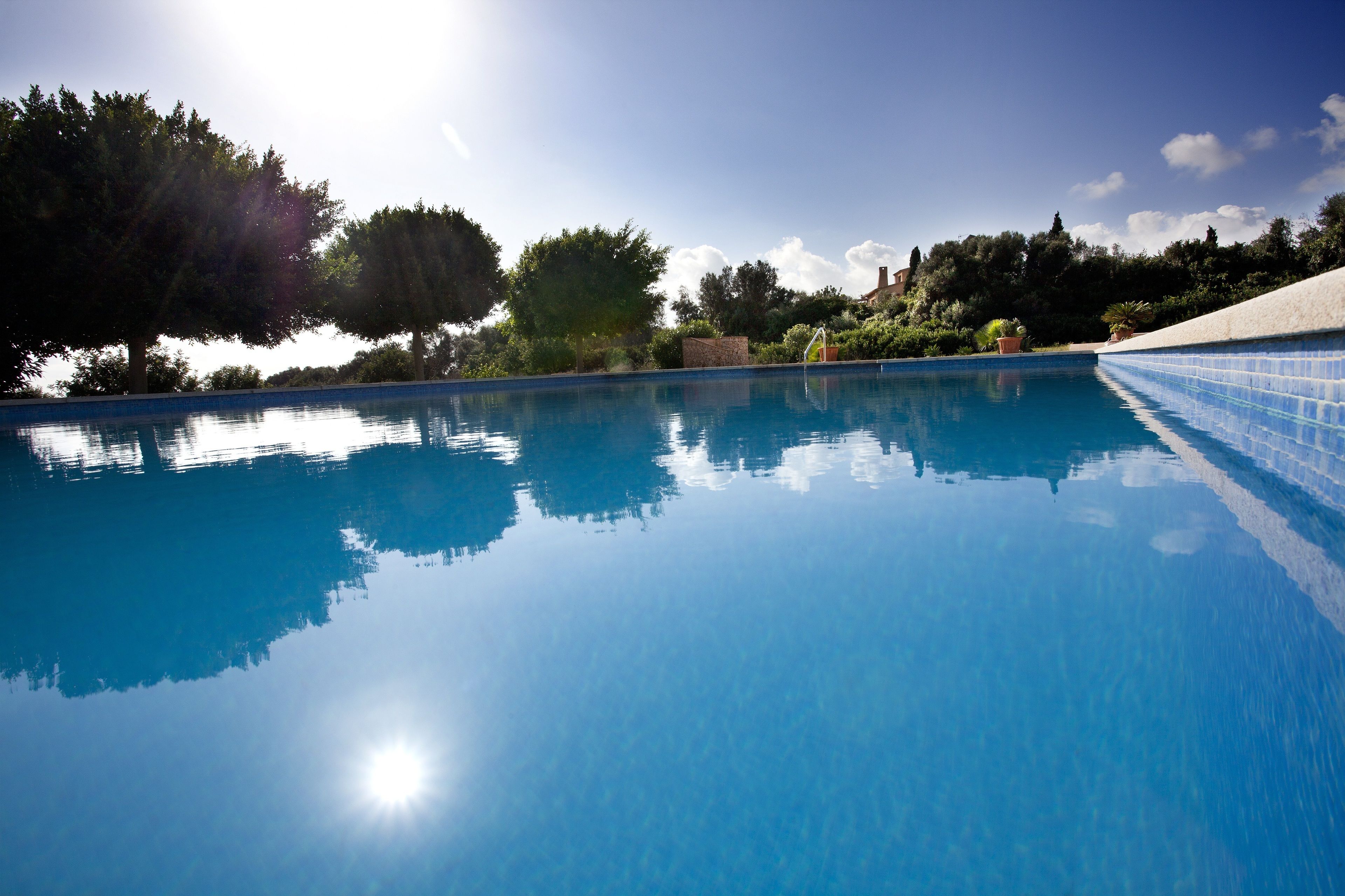Una piscina al aire libre de temporada, sombrillas, tumbonas