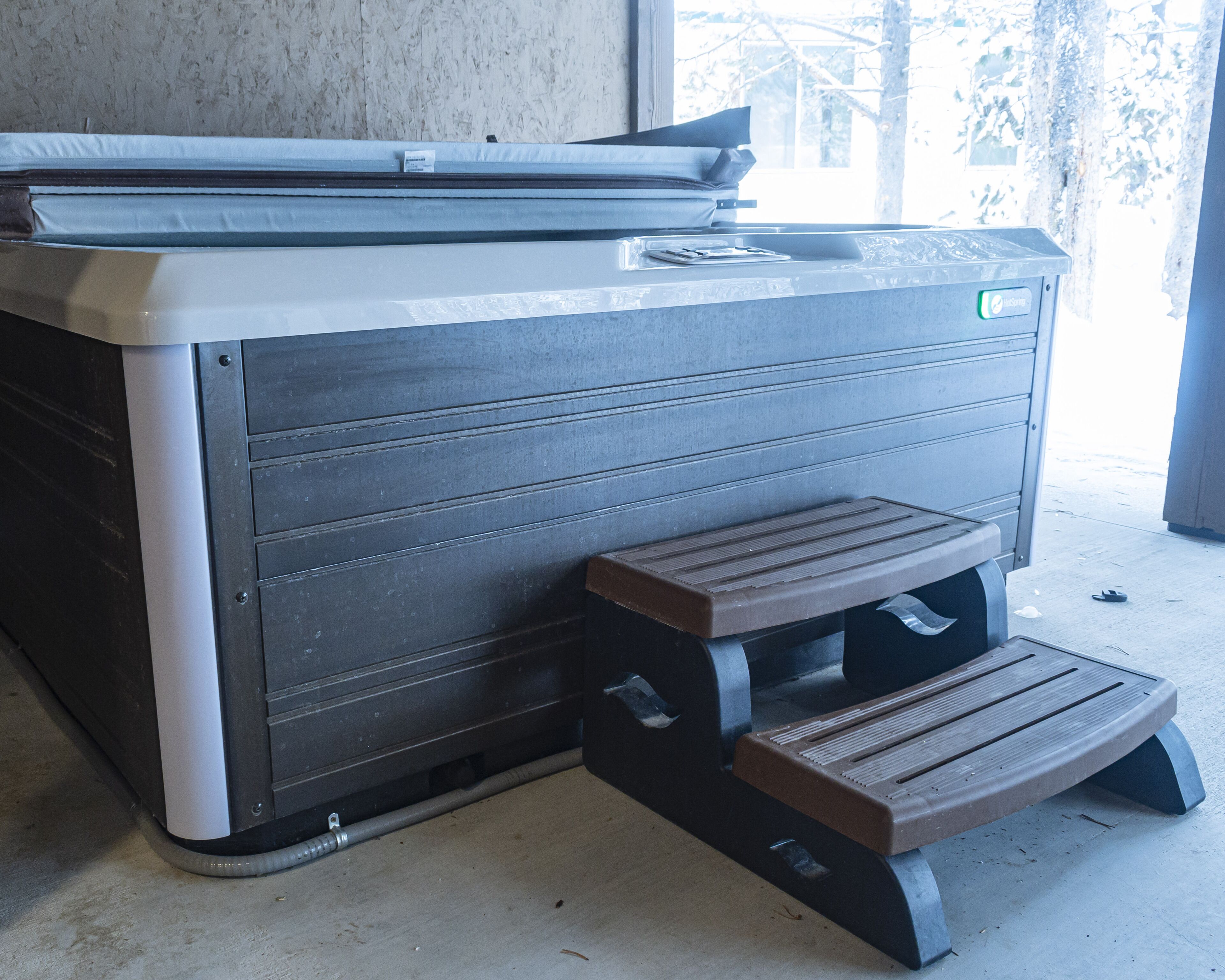 A large industrial printer with a step stool and a control panel.