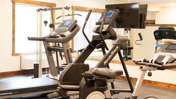 Ein Fitnessraum mit Laufbändern und einem Crosstrainer.