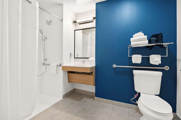 A modern bathroom with a shower, toilet, and sink.