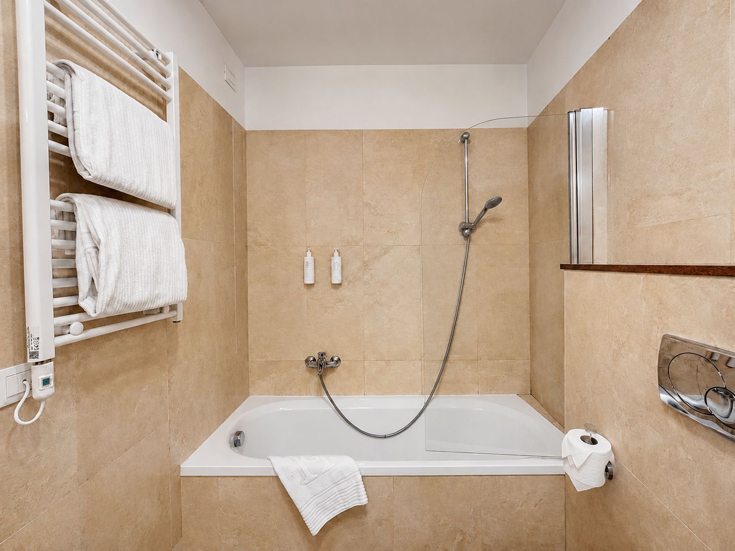 A modern bathroom with a bathtub, a shower, and a towel rack.