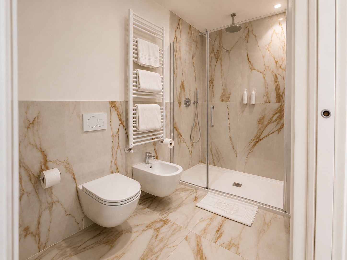 A modern bathroom with a toilet, bidet, and a glass-enclosed shower area.