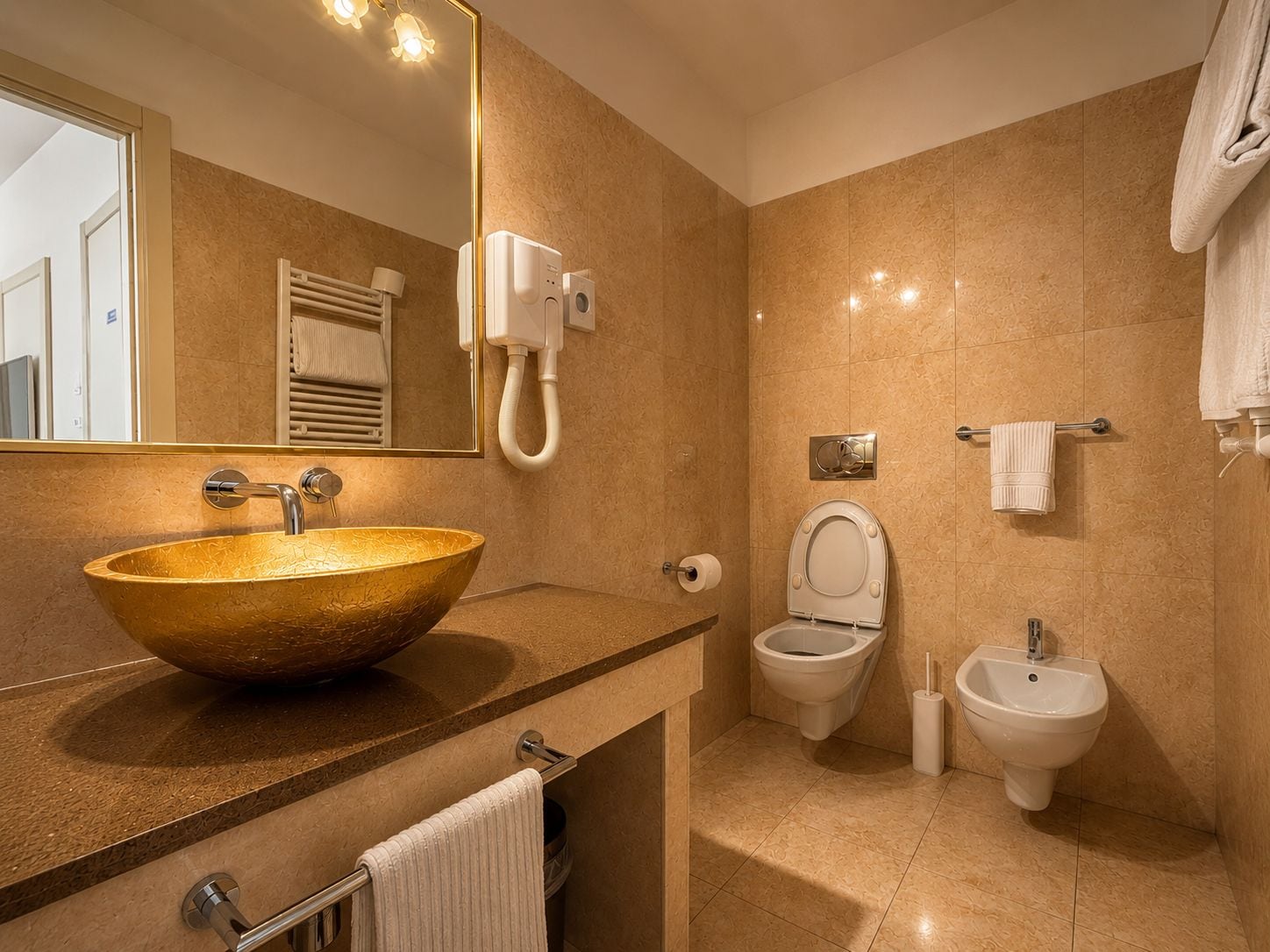 Une salle de bain moderne avec un grand lavabo sur colonne, des toilettes et un bidet.