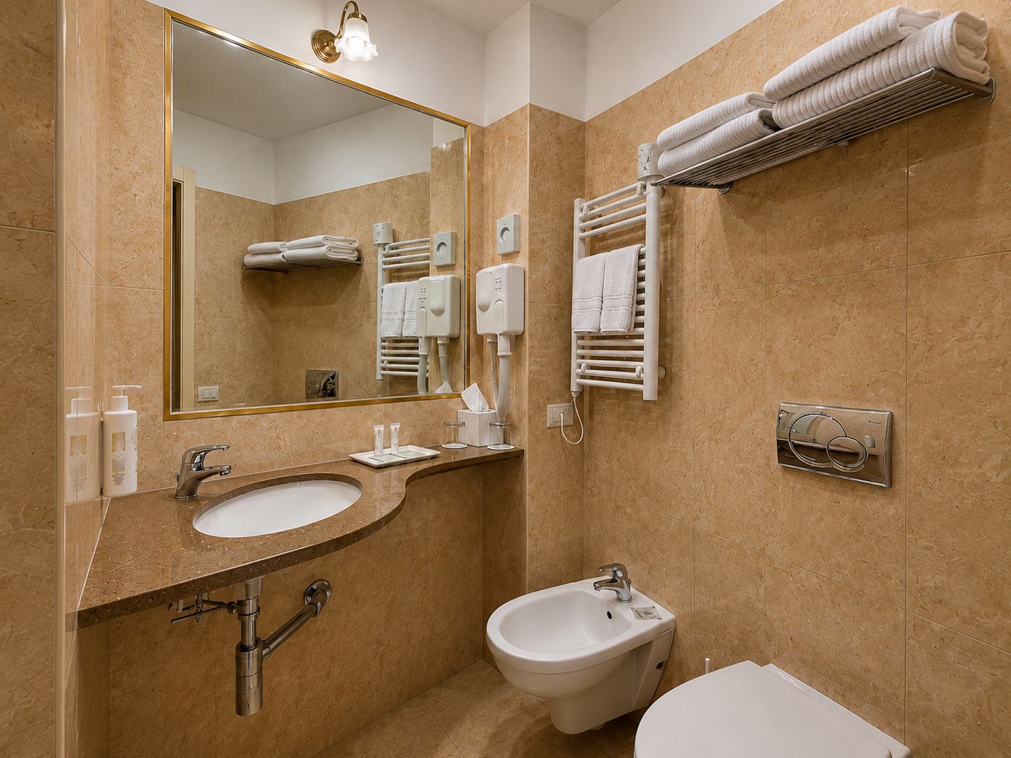 A modern bathroom with a sink, bidet, and towel rack.