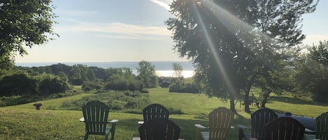 Un espacio al aire libre cubierto de césped, con varias sillas Adirondack dispuestas para sentarse.