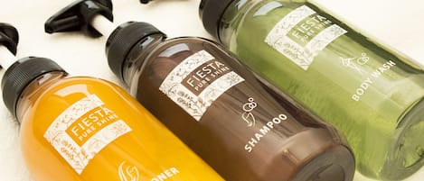 Three bottles of Fiesta Pure Shine body wash in different colors.