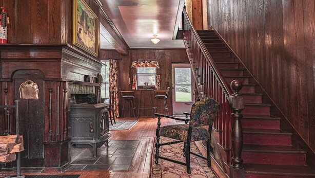 A wooden interior with a staircase, a fireplace, and a dining area. - Black Mountain Inn (Black Mountain)