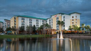 A hotel with a modern design, featuring multiple floors and a central courtyard with a fountain.