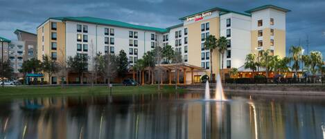 A hotel with a modern design, featuring multiple floors and a central courtyard with a fountain.