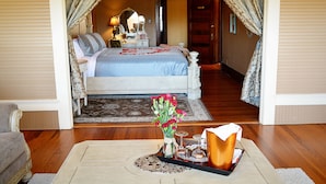 Une chambre à coucher avec un lit, une table de chevet, une lampe et un vase de fleurs.
