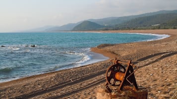 Na praia, espreguiçadeiras, guarda-sóis 