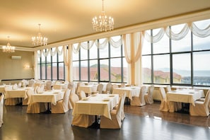 Enjoy meals in a beautifully appointed dining area with large windows and elegant chandeliers.