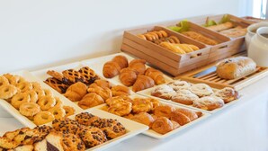 Diversitat de pastissos i productes de forneria exposats en safates i plats.