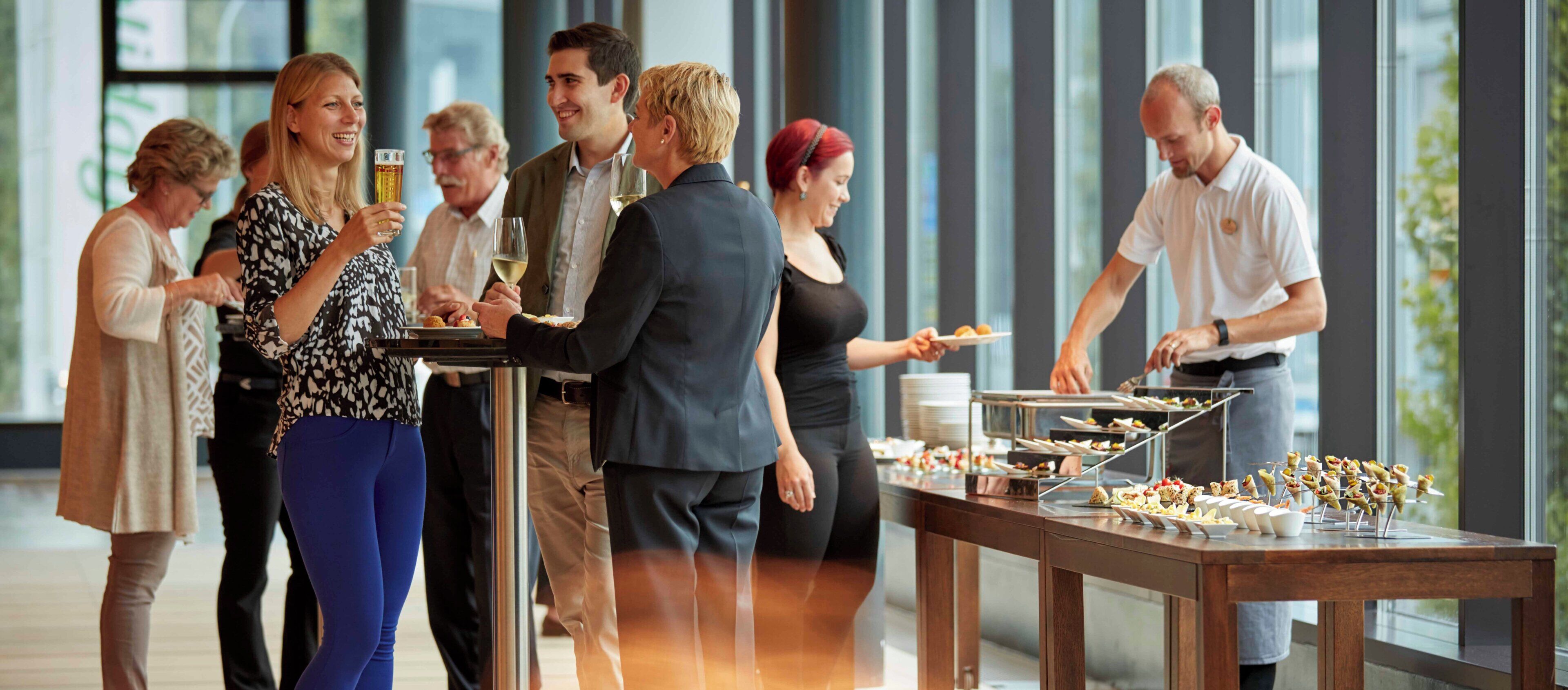 A group of people at a buffet with a variety of food items and drinks.