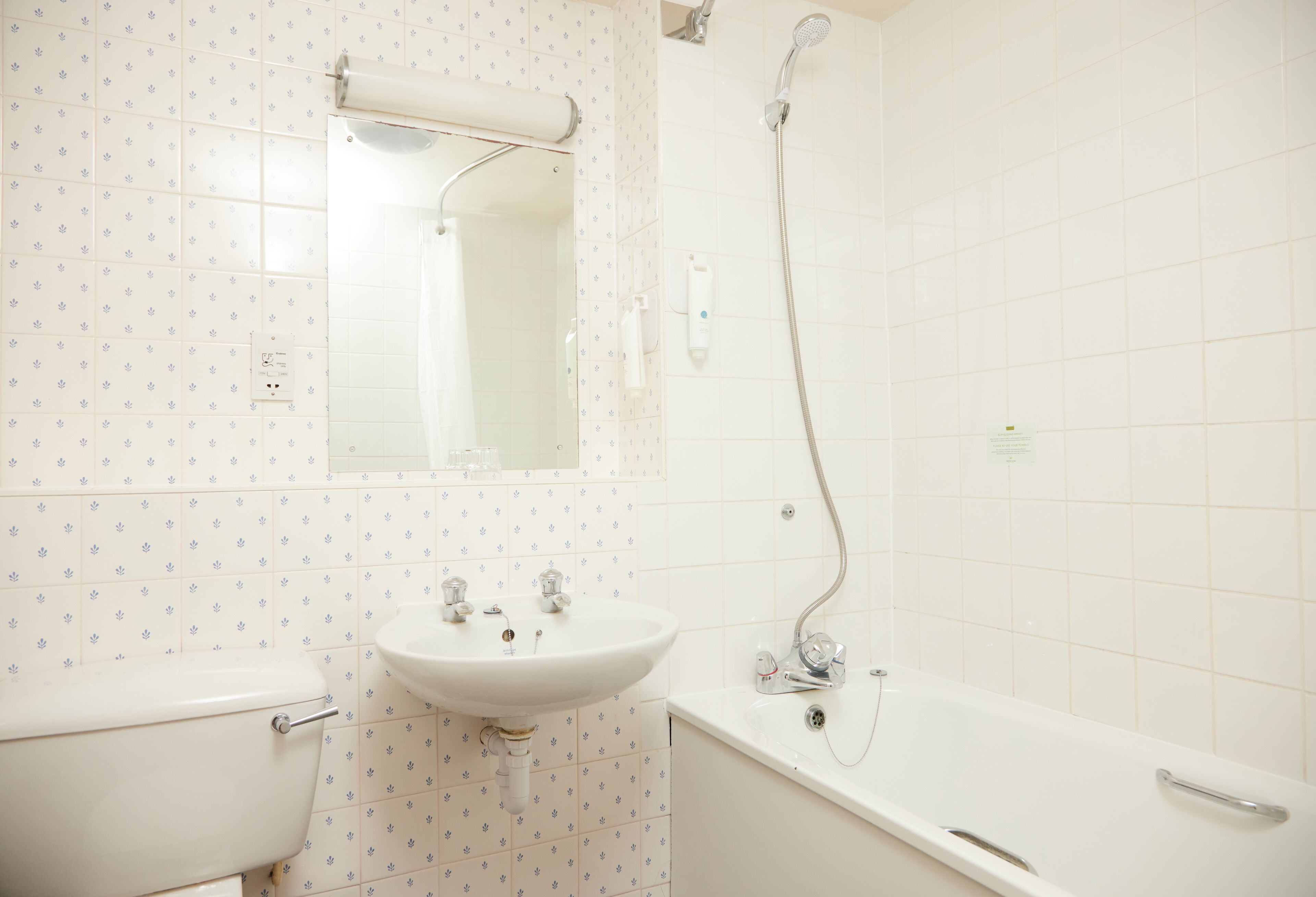 A bathroom with a toilet, sink, mirror, shower, and bathtub.