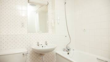 Un baño con inodoro, lavamanos, espejo, ducha y bañera.