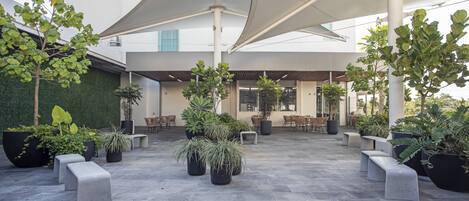 An outdoor seating area with planters and umbrellas.