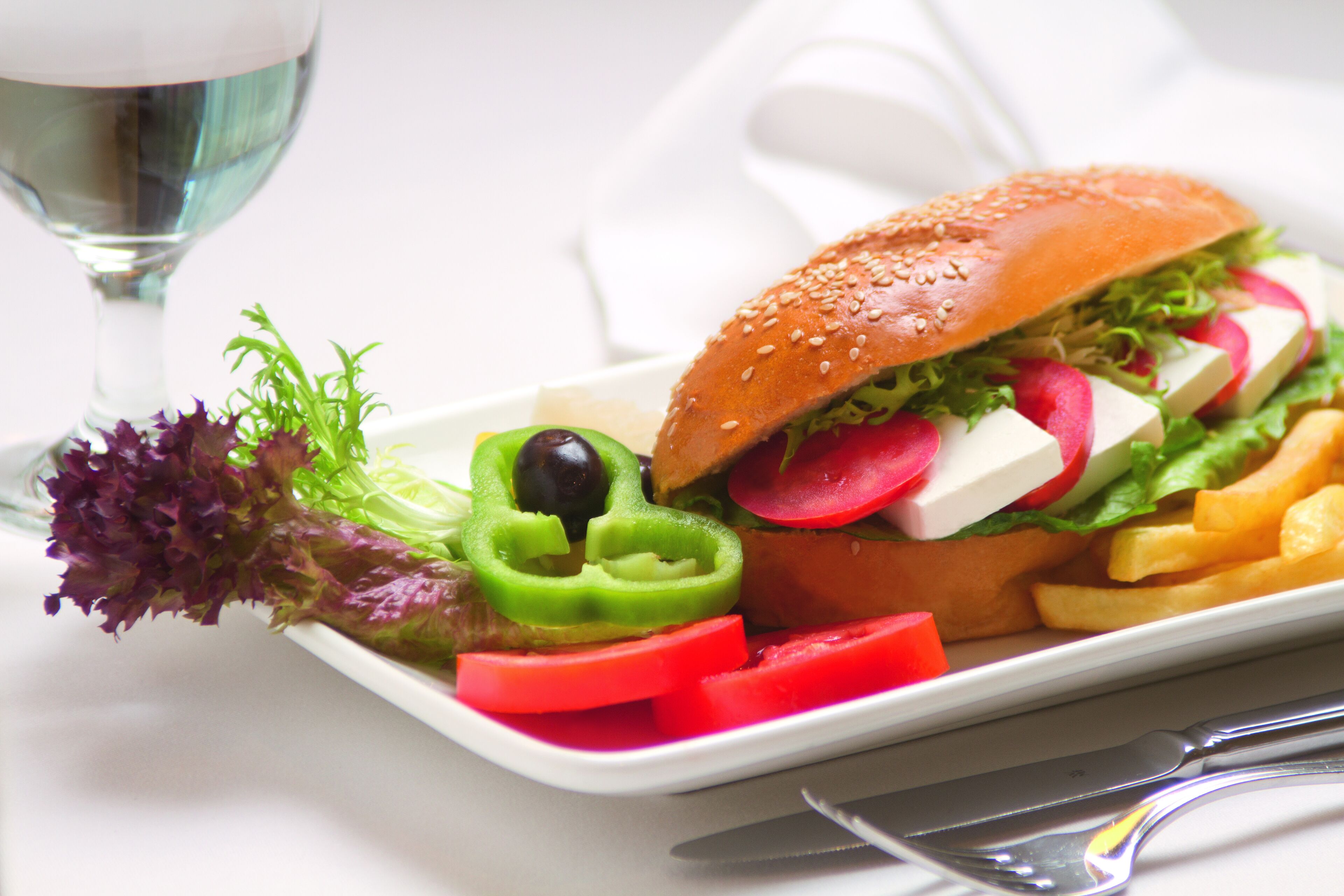 A plate with a sandwich, fries, and a glass of water.