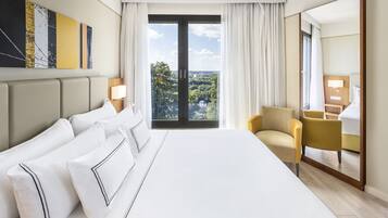 Une chambre d’hôtel avec un grand lit, une chaise, un bureau et une vue sur l’extérieur.