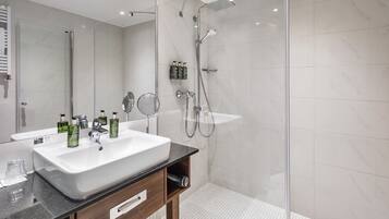 Un bagno moderno con un lavandino ampio, uno specchio e una doccia.