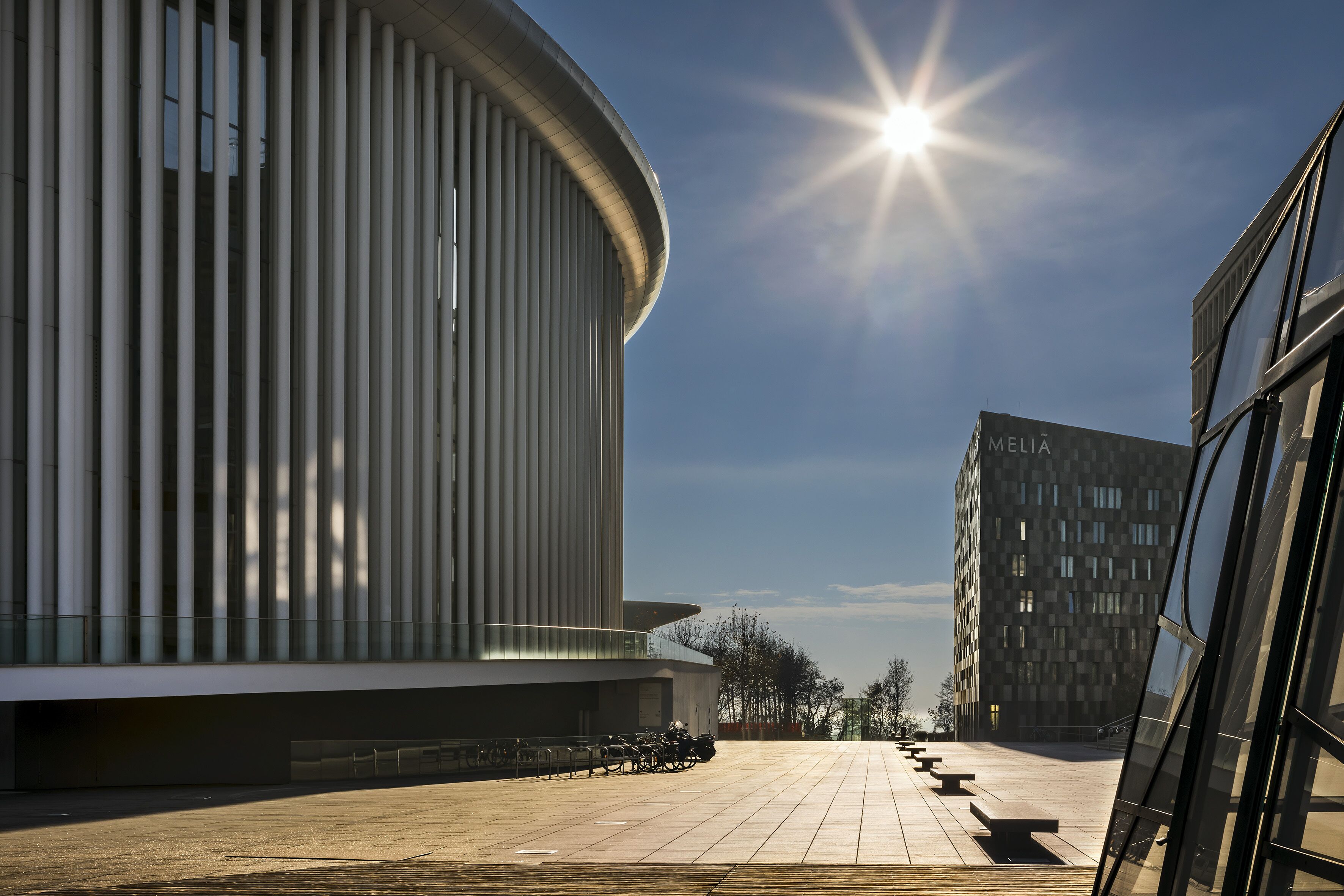 Un bâtiment moderne à la façade incurvée, avec un ciel dégagé.
