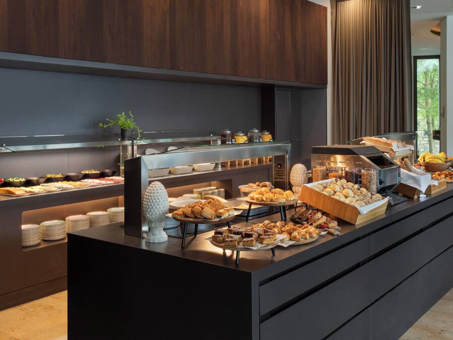 A buffet with various food items and a coffee station.