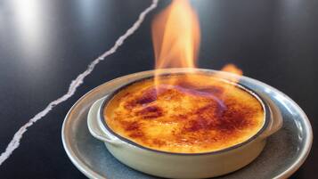 A crème brûlée on a plate with a flame above it.