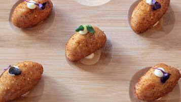 Five croquettes on a wooden board.