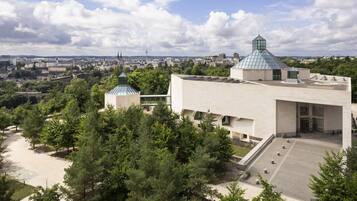 A modern building with a flat roof and a glass dome structure.