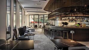 Een moderne bar met een gebogen toonbank, zitgedeeltes en uitzicht op het omliggende landschap.