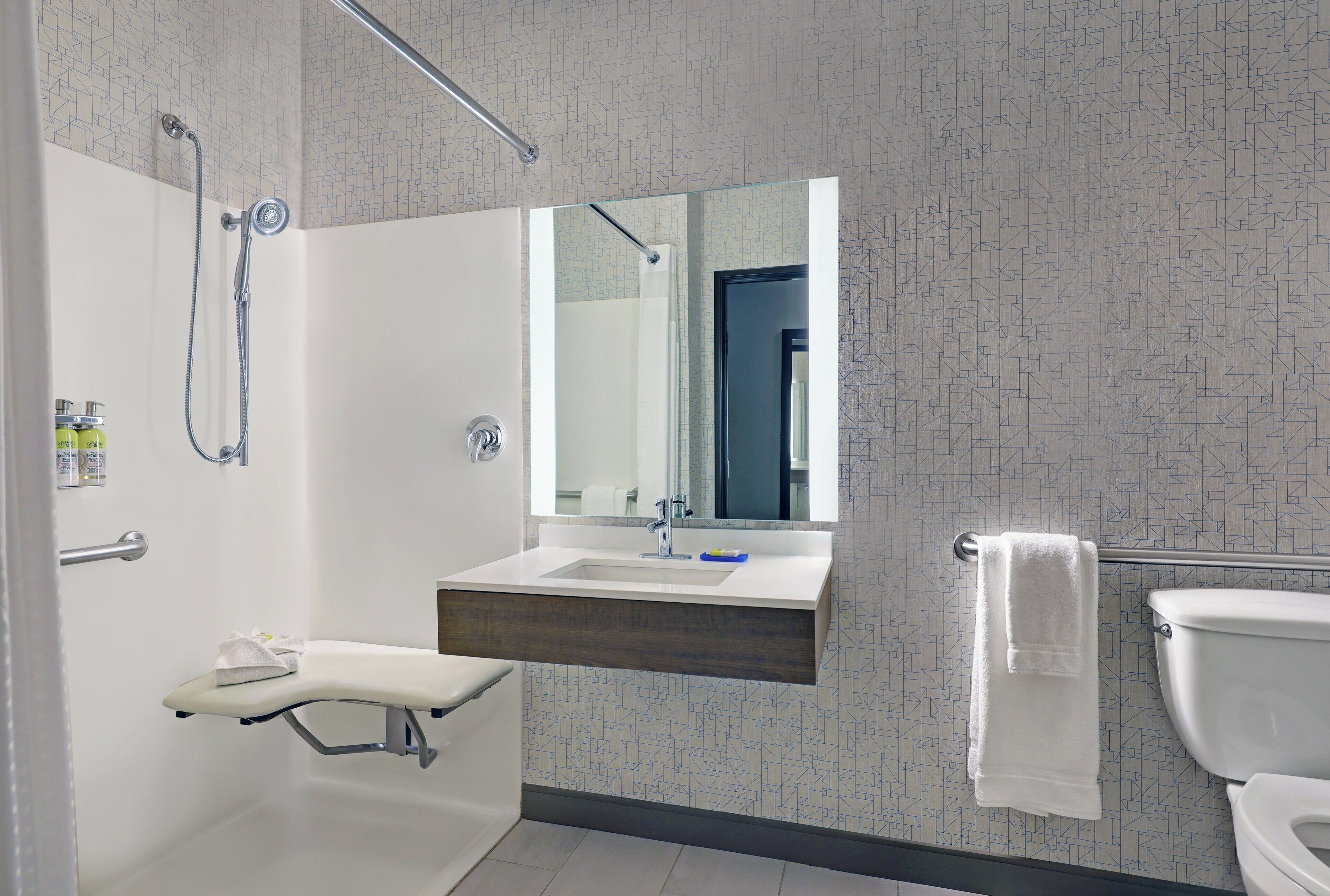 Un bagno moderno con doccia, lavandino e WC.