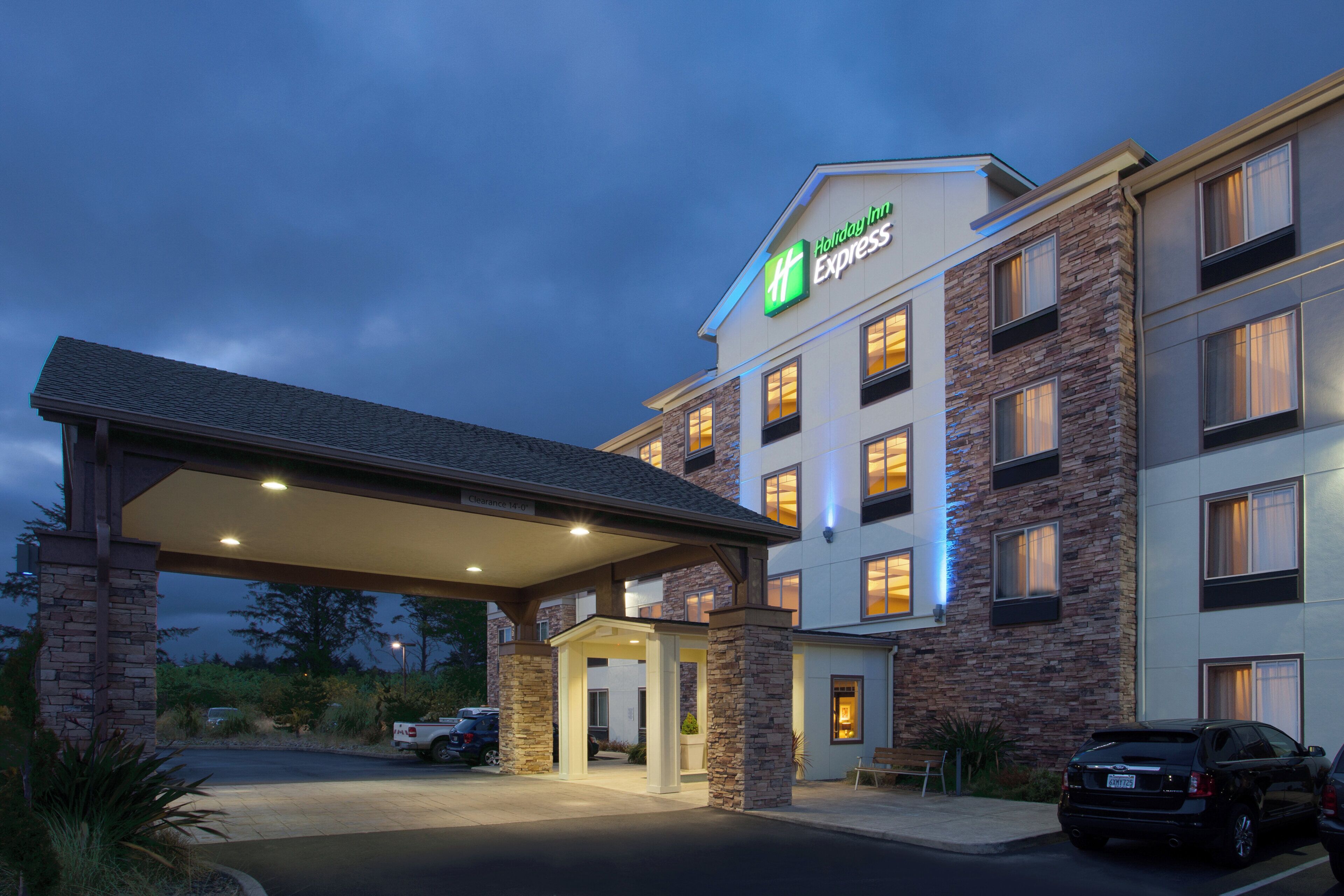 A Holiday Inn Express hotel with a covered entrance, multiple windows, and a parking area.