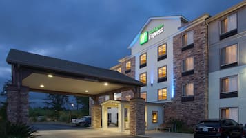 A Holiday Inn Express hotel with a covered entrance, multiple windows, and a parking area.