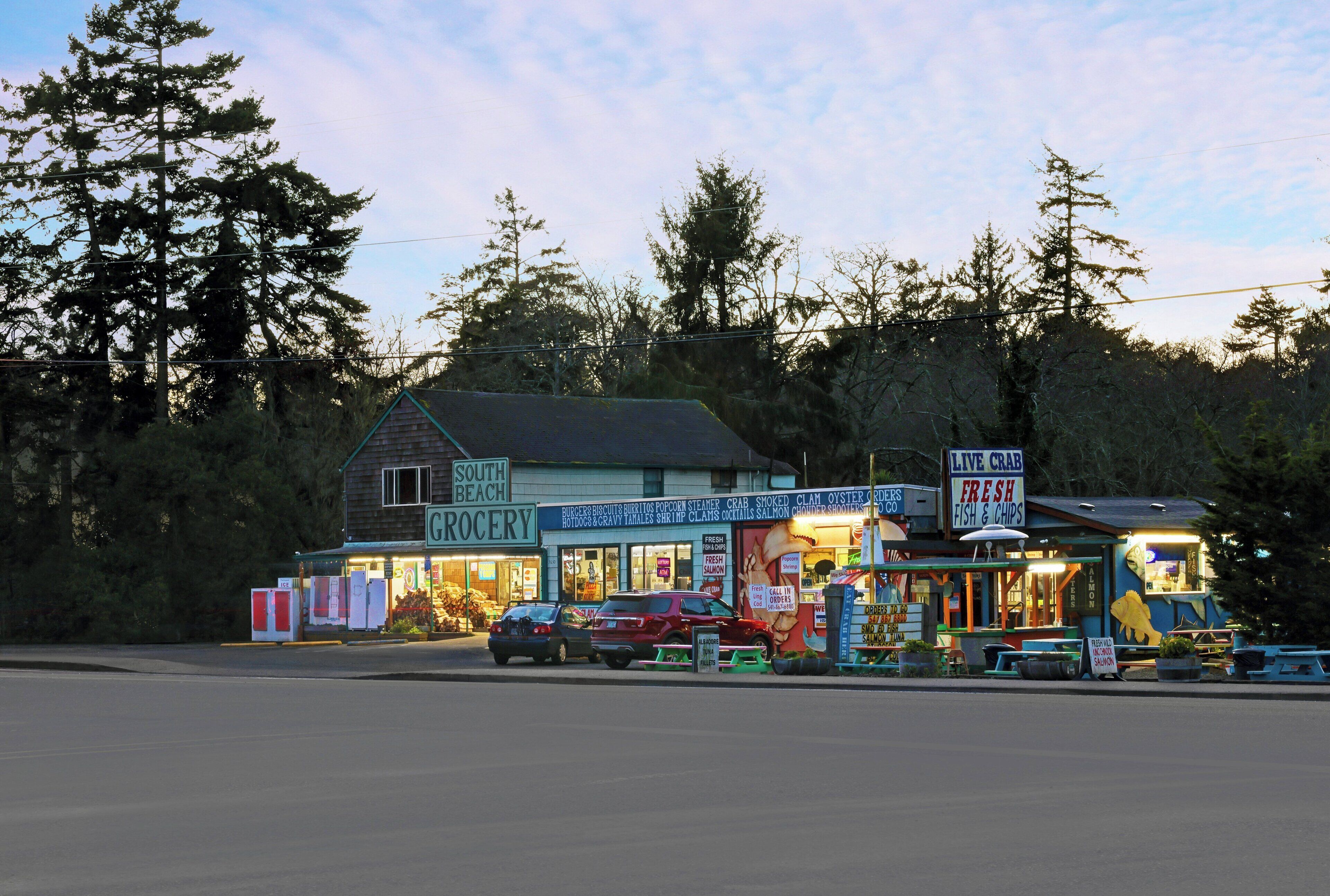 A grocery store with a sign for live crab and fresh fish & chips.