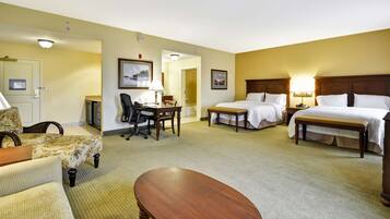 Une chambre d’hôtel avec deux lits, un bureau, une chaise, un canapé et une petite table.