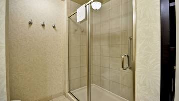 A shower with a glass door, a toilet, and a towel rack.